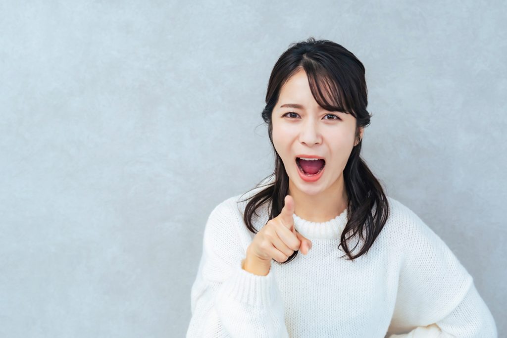 指をさしてる女性